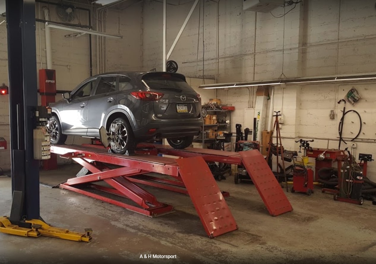 Car on hydraulic lift in auto repair shop in Warminster PA for maintenance service